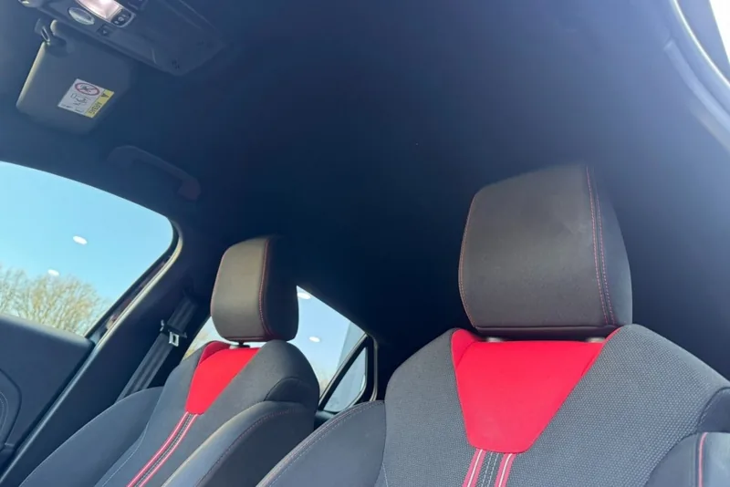Achterbank van een Opel Corsa met rode accenten in de hoofdsteunen