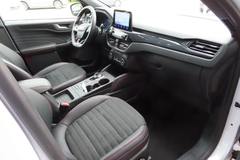 Interieur van een Ford Kuga ST-Line X met centraal scherm en stoffen bekleding met rode stiksels