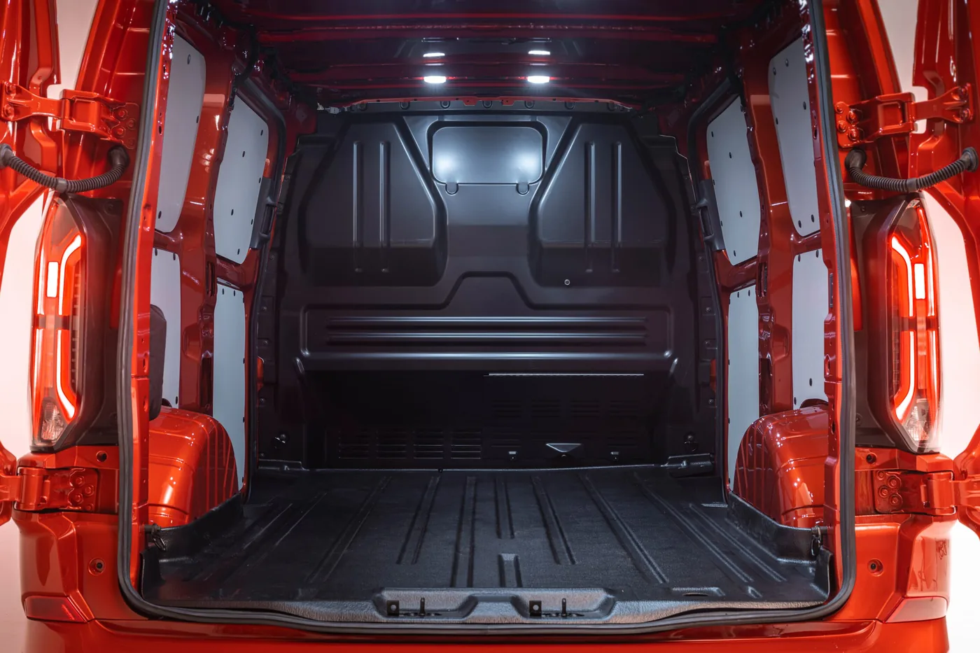 Lege laadruimte van de Ford Transit Custom gezien door de geopende achterdeuren met sjorogen in de laadvloer