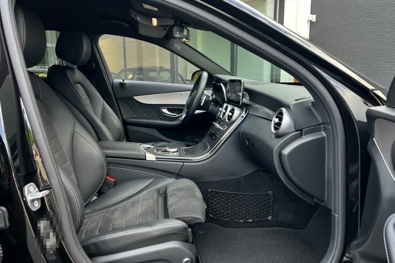Interieur van een Mercedes-Benz C-Klasse gezien vanaf de passagierszijde met geopend portier