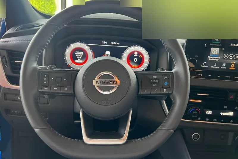 Dashboard van een Nissan Qashqai met digitale klokken en centraal scherm