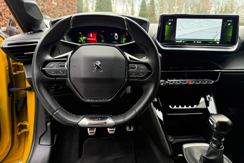 Het i-Cockpit van de Peugeot 208: klein stuur laag, instrumenten daarboven, toggle switches onder het centrale scherm